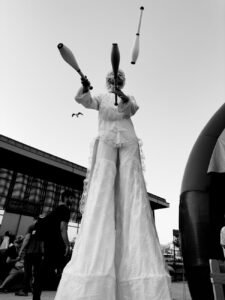 juggler on stilts in black and white